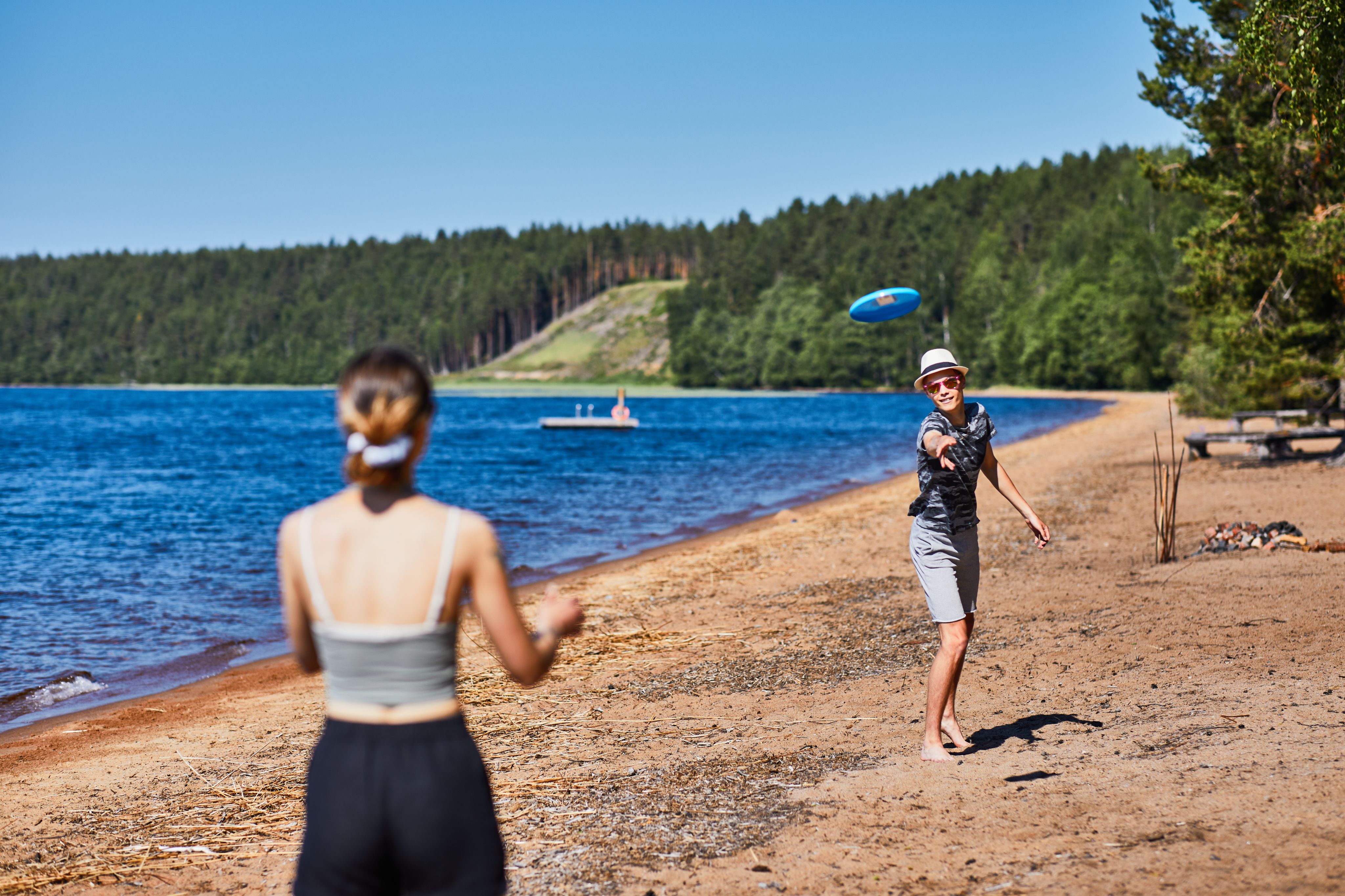 Poika heittää frisbeetä Huuhanrannalla